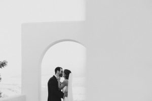 Novios compartiendo un beso en un arco blanco del Hotel Fairplay con vistas panorámicas fotografía de EsebeWedding