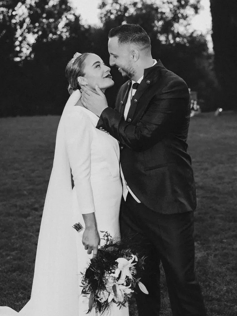 Pareja de novios abrazándose durante una boda en Sevilla, fotografía documental en blanco y negro